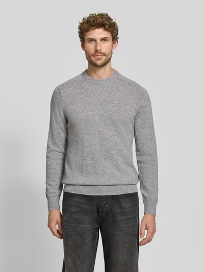 Männermodel trägt Regular Fit Strickpullover aus reinem Kaschmir von FTC Cashmere in Grau, glatte Textur, Ganzkörperansicht von vorne.