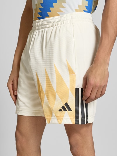 Männermodel trägt Regular Fit Sweatshorts mit Strukturmuster von adidas Sportswear, Optik: Unifarben, feines Strukturmuster, Label-Print, Kontraststreifen-Print, elastischer Bundabschluss mit Tunnelzug, seitliche Eingrifftaschen, Nahaufnahme Oberschenkel.