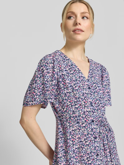 Frauenmodel trägt Leicht ausgestelltes Minikleid aus reiner Viskose Modell 'ALBA' von Vero Moda, Optik: Unifarben, V-Ausschnitt, Taillengürtel, Kurzarm, Nahaufnahme Oberkörper.