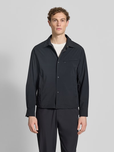 Männermodel trägt Blouson mit Kentkragen und Brusttasche von ARMANI EXCHANGE in Dunkelblau, glatte Struktur, Ganzkörperansicht von vorne. Material-Mix mit Stretch, Regular Fit, Knopfleiste, Reißverschluss-Brusttasche, Rückenlänge bei Größe M 66 cm.