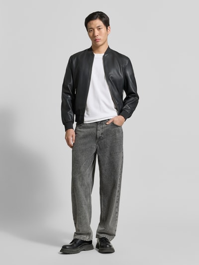 Männermodel trägt Bomberjacke in Leder-Optik mit Zweiwege-Reißverschluss von MARKUP, Material-Mix mit Viskose-Anteil, Regular-Fit, Stehkragen, schwarze Farbe, glatte Textur, Ganzkörperansicht von vorne.