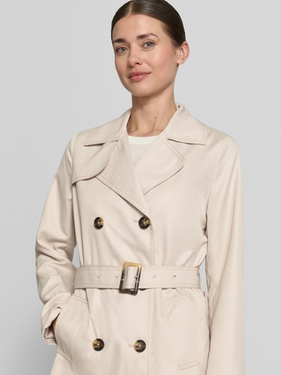 Frauenmodel trägt Trenchcoat mit Gürtel und seitlichen Eingrifftaschen von Zero in Beige, Doppelreiher, Reverskragen, Nahaufnahme Oberkörper.