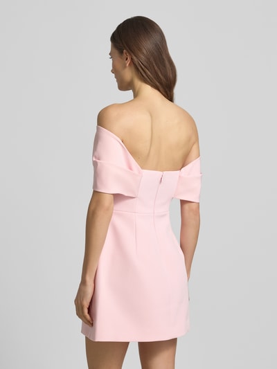 Modelka nosi sukienkę mini Regular Fit Minikleid mit Zierschleife Modell 'Scottie' od Forever New, elastyczna mieszanka materiałów, kolor jasnoróżowy, krój regular fit, ozdobna kokarda, model z odkrytymi ramionami, taliowany fason, rozkloszowany dół, długość tyłu w rozmiarze 36: 57 cm, szerokość w rozmiarze 36: 35 cm, zdjęcie całej sylwetki z tyłu.