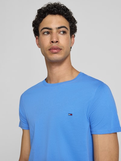 Männermodel trägt Regular Fit T-Shirt aus reiner Baumwolle von Tommy Jeans, Optik: Unifarben, Logo-Stitching, Rundhals, Jersey, Nahaufnahme Oberkörper.