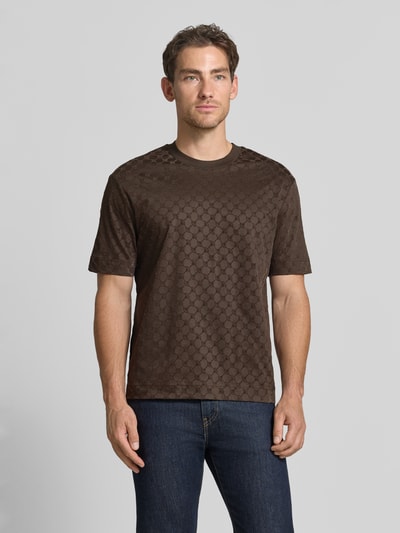 Männermodel trägt Regular Fit T-Shirt aus reiner Baumwolle Modell 'Varo' von JOOP! COLLECTION in Dunkelbraun mit dezentem Muster, Ganzkörperansicht von vorne.