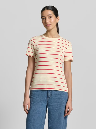 Frauenmodel trägt Slim Fit T-Shirt aus reiner Baumwolle von Tommy Hilfiger, Optik: Unifarben mit Logo-Stitching, Rundhals, Kurzarm, Jersey, Ganzkörperansicht von vorne.