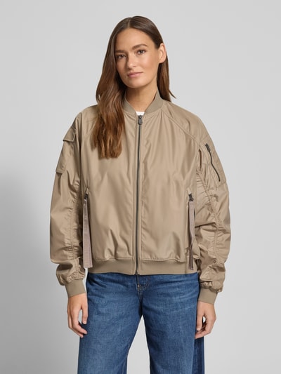 Vrouwenmodel draagt Bomberjack met ritszakken model 'LIL' van SAVE THE DUCK in materiaalmix met stretch, regular fit, opstaande kraag, lichtbruin, detail stiknaden, jeans, voorkant, Ganzkörperansicht von vorne. Ruglengte maat S 53 cm, schouderbreedte 42 cm, borstwijdte 61 cm, mouwlengte 70 cm.