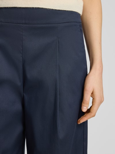 Frauenmodel trägt Hose mit weitem Bein und Bügelfalten von Windsor aus dunkelblauem Baumwoll-Mix mit Stretch-Anteil, Nahaufnahme Oberkörper.