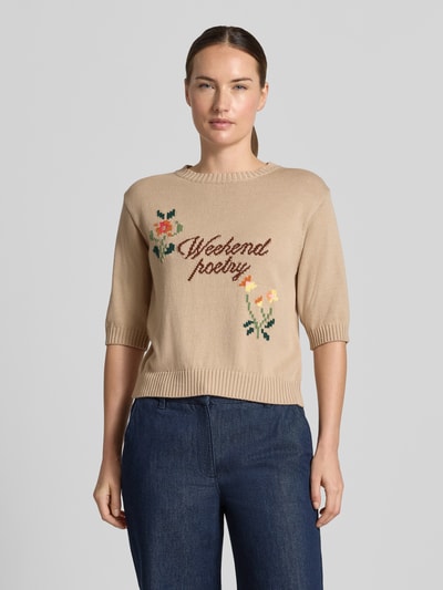 Vrouwenmodel draagt regular fit gebreid shirt van katoenmix model 'FIACRE' van Weekend Max Mara, beige met geborduurde tekst en bloemen, voorkant bovenlichaam