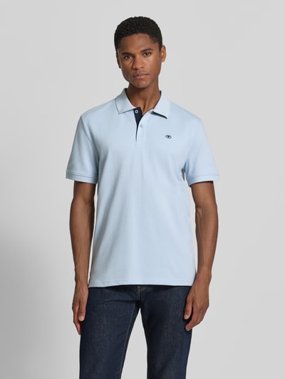 Männermodel trägt Regular Fit Poloshirt aus reiner Baumwolle von Tom Tailor in Hellblau, klassischer Kragen, feine Struktur, Ganzkörperansicht von vorne. Herren Poloshirt von Tom Tailor.