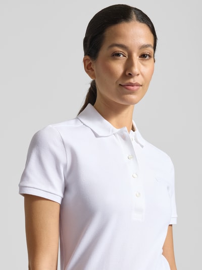Frauenmodel trägt Regular Fit Poloshirt aus Baumwoll-Mix von Lacoste Sport, weiß, kurze Ärmel, Logo-Stitching, Nahaufnahme Oberkörper.