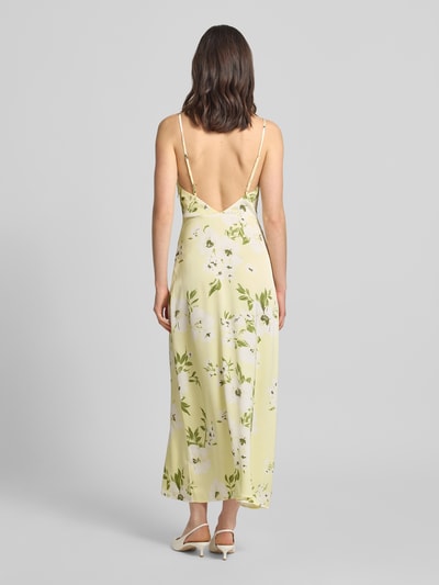 Frauenmodel trägt Midikleid im Allover-Look Modell 'RAVENNA' von Vila aus glänzendem Satin in Gelb mit floralen Mustern, Spaghettiträger, Gerader-Schnitt, Wasserfall-Ausschnitt, Rückenlänge 126 cm bei Größe 36, Brustweite 33 cm, Ganzkörperansicht Rückansicht.