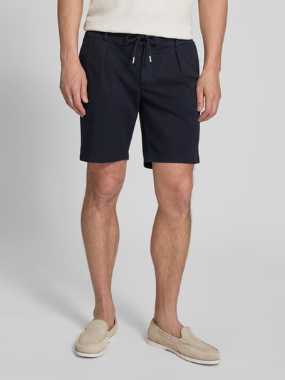 Männermodel trägt Straight Fit Shorts mit Bundfalten von Profuomo in Dunkelblau, elastischer Bund, Eingrifftaschen, Ganzkörperansicht von vorne.