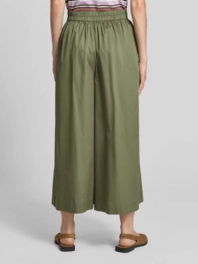 Frauenmodel trägt Wide Fit Stoffhose mit Bundfalten von Christian Berg Woman in Olivgrün, reine Baumwolle mit elastischem Bund, Ganzkörperansicht Rückansicht.