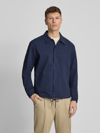 Männermodel trägt Regular Fit Blouson aus Baumwoll-Mix Modell 'SEERSUCKER' von Polo Ralph Lauren, Optik: Unifarben, Muster: Gestreift, Logo-Stitching, Kragenform: Umlegekragen, Verschluss: Druckknopfleiste, seitliche Eingrifftaschen, Materialverarbeitung: Twill-Stretch, Farbe: Dunkelblau, Textur: Feine Struktur, Ganzkörperansicht von vorne.
