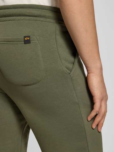 Männermodel trägt Shorts mit Eingrifftaschen und Logo-Print von Alpha Industries in Olivgrün, Baumwoll-Mix mit Gesäßtasche, Detailaufnahme Rückansicht.
