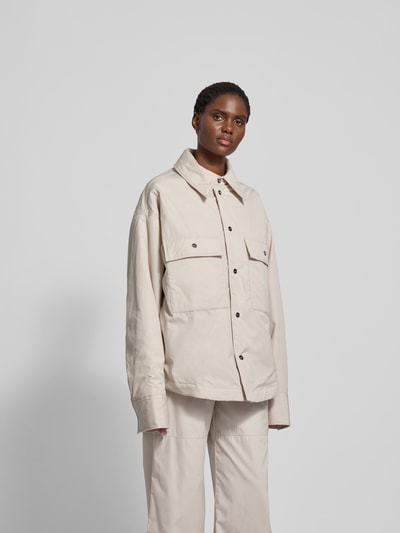 Frauenmodel trägt Jacke mit Hemdblusenkragen von black palms, Reine Baumwolle, Lockerer-Schnitt, Druckknopfleiste, Brusttaschen, Ganzkörperansicht von vorne.