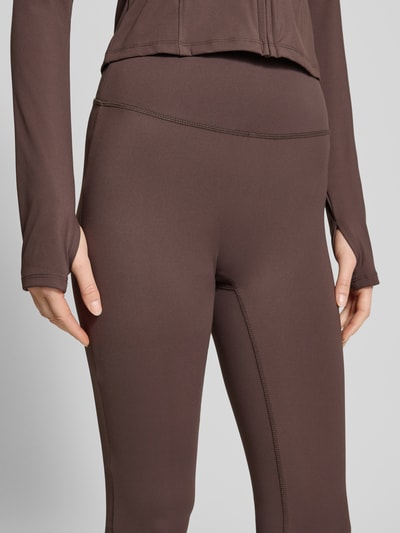 Frauenmodel trägt Flared Fit Leggings mit breitem Bund Modell 'Yoga' von Gina Tricot, elastischer Material-Mix, Nahaufnahme Oberkörper.