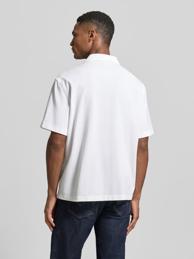 Männermodel trägt Relaxed Fit Freizeithemd aus reiner Baumwolle von Lacoste, unifarben, kurzarm, strukturierte Piqué-Optik, Ganzkörperansicht Rückansicht.