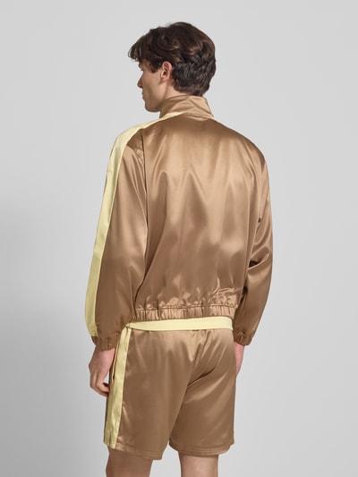 Männermodel trägt Schimmernde Trainingsjacke mit Label-Stitching von BLKVIS in Gold mit Stehkragen und Reißverschluss, Rückenansicht Ganzkörperansicht. Regular-Fit Herren Trainingsjacke, Rückenlänge bei Größe M: 61 cm, Ärmellänge: 63 cm, glatte schimmernde Oberfläche.