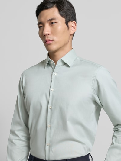 Männermodel trägt Regular Fit Business Hemd aus Baumwolle mit Kentkragen von Jake*s in Hellgrün, glatte Textur, Nahaufnahme Oberkörper. Rückenlänge 70 cm, Schulterbreite 47 cm, Ärmellänge 64 cm.