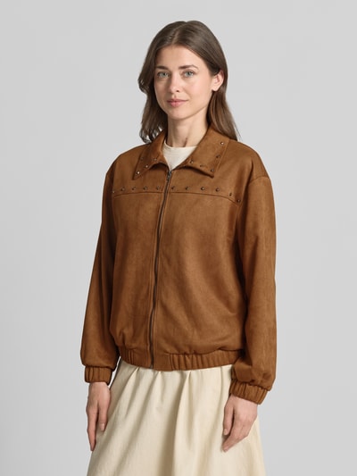 Kobieta prezentuje bomberkę Regular Fit Bomberjacke mit Nieten model 'ANDREA' od Vero Moda, efekt: jednolity kolor, zamek błyskawiczny, nity, długi rękaw, elastyczne zakończenia, wpuszczane kieszenie; zdjęcie: ujęcie całej sylwetki z przodu.