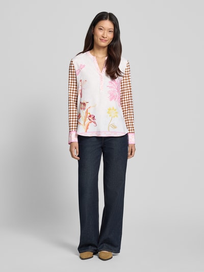 Vrouwenmodel draagt Relaxed Fit tuniek-blouse uit zijdemix met bloemen all-over print van HERZENS, ruglengte 70 cm, maat 36, langemouwen, tuniekhals, voorkant volledige lichaamsweergave