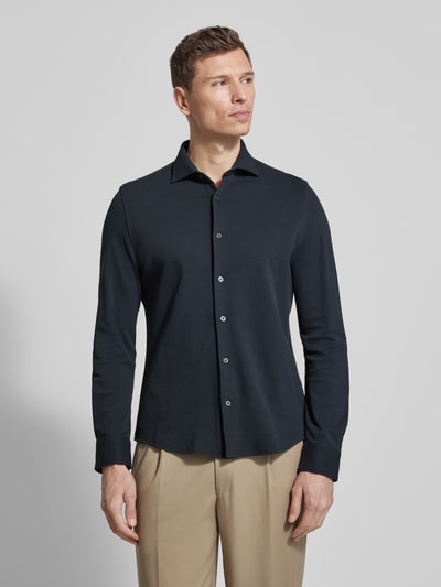 Männermodel trägt Shaped Fit Freizeithemd aus reiner Baumwolle von Marc O'Polo, unifarben, Cutaway-Kragen, Piquétextur, Ganzkörperansicht von vorne.