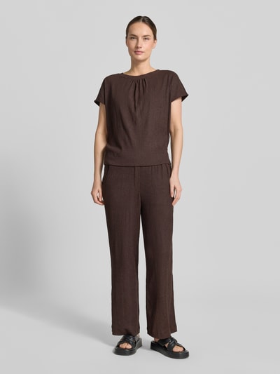 Frauenmodel trägt Regular Fit Damen T-Shirt mit Strukturmuster Modell 'Salti' von OPUS, Elastischer-Material-Mix, Kurzärmelig, Raffungen, Rundhalsausschnitt, Rückenlänge bei Größe 36: 53 cm, einfarbig braun, weiche Textur, Ganzkörperansicht von vorne.