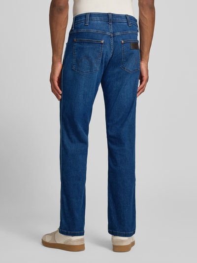 Männermodel trägt Straight Fit Jeans im 5-Pocket-Design Modell 'Greensboro' von Wrangler aus Baumwoll-Mix mit Stretch-Anteil, Ganzkörperansicht Rückansicht.