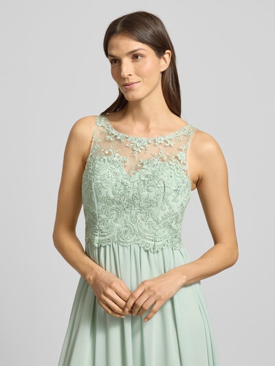Frauenmodel trägt Regular Fit Abendkleid mit floralem Spitzenbesatz von Laona, semitransparentes Design, Nahaufnahme Oberkörper.