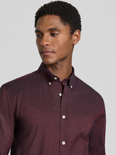 Męskamodel nosi Regular Fit koszulę casualową z mieszanki bawełny i elastanu Model 'Oxford' od Lindbergh, kolor bordowy, zbliżenie na górę ciała, długość tyłu w rozmiarze M: 77 cm, szerokość ramion w rozmiarze M: 44 cm, długość rękawów w rozmiarze M: 66 cm, kołnierzyk typu button down, mankiety zapinane na 1 guzik, zaokrąglony dół