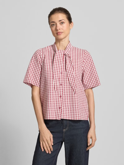 Vrouwenmodel draagt strikblouse met knoopsluiting van Jake*s Casual, recht model, strikkraag, 1/2-mouwen, geruit, casual stijlen, ruglengte maat 36: 60 cm, mouwlengte maat 36: 24 cm, voorkant volledig zichtbaar, opname van bovenlichaam.