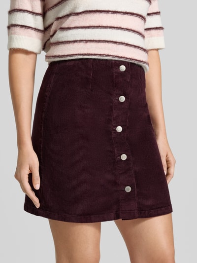 Kobiece modelka nosi Regular Fit Mini-Rock aus Baumwoll-Mix Modell 'ETTA' od VERO MODA, mieszanka modalu i bawełny, bordowa, guziki z przodu, spódnica mini, damska, zbliżenie na dolną część tułowia