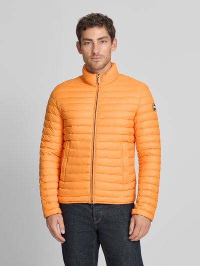 Männermodel trägt Steppjacke mit Zweiwege-Reißverschluss von Colmar Originals in Orange, Regular-Fit, Stehkragen, Eingrifftaschen, Ganzkörperansicht von vorne. Kontext: Rückenlänge bei Größe 50: 65 cm, Schulterbreite: 47 cm, Brustweite: 43 cm, Ärmellänge: 67 cm.