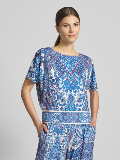 Modelka kobieta ma na sobie damski t-shirt z mieszanki materiałów z dodatkiem streczu, krój regular fit, wzór na całej powierzchni, okrągły dekolt, długość tyłu w rozmiarze 36: 50 cm, długość rękawów w rozmiarze 36: 19 cm, T-Shirt mit Allover-Look od Oui, widok całej sylwetki z przodu.
