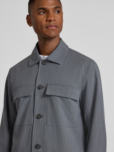 Männermodel trägt Regular Fit Jacke mit Viskose-Anteil Modell 'Grahn' von Casual Friday, grauer Stoff mit Brusttaschen, Nahaufnahme Oberkörper.