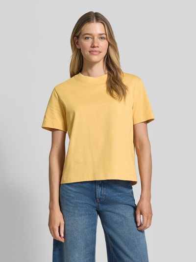 Modelka nosi Boxy Fit T-Shirt aus reiner Baumwolle Modell 'ESSENTIAL' von Selected Femme, żółty heavy jersey, jednokolorowy, naszywka label patch, okrągły dekolt, krótki rękaw, widok całej sylwetki z przodu.