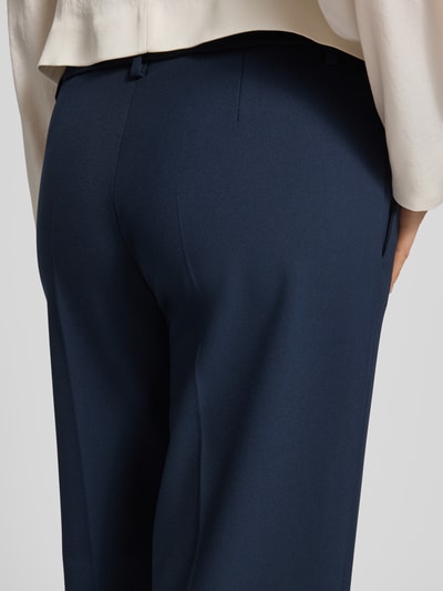 Frauenmodel trägt Wide Fit Stoffhose mit Viskose-Anteil Modell 'Olessa' von Raffaello Rossi, Dunkelblau, Crêpe, Detailaufnahme Rückansicht. Elastischer-Material-Mix, Bügelfalten, Haken- und Reißverschluss, Bundweite 41 cm, Innenbeinlänge 66 cm, Damen.