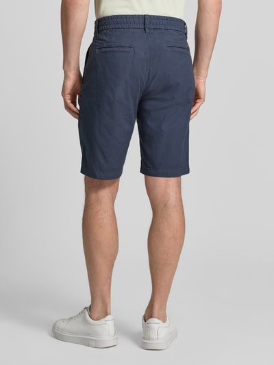 Männermodel trägt Tapered Chinoshorts aus Baumwoll-Mix Modell 'CHINO_TAPERED_DS_3S' von BOSS Orange, dunkelblau, unifarben, Ganzkörperansicht Rückansicht