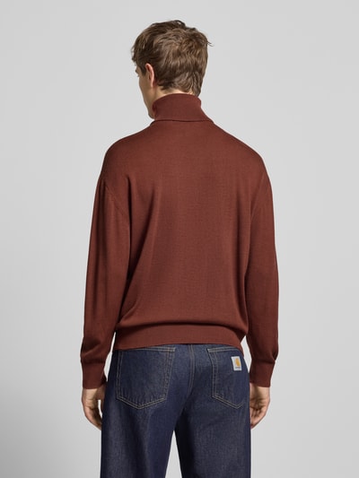 Männermodel trägt Loose Fit Rollkragenpullover aus Woll-Mix von BLKVIS in Braun mit gerippten Abschlüssen und Label-Stitching, Ganzkörperansicht Rückansicht.