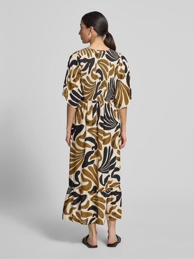 Frauenmodel trägt Midikleid aus Viskose mit Smok-Details Modell 'FELDI' von Soyaconcept, taillierter Schnitt, Rückenlänge 119 cm, Ganzkörperansicht Rückansicht.