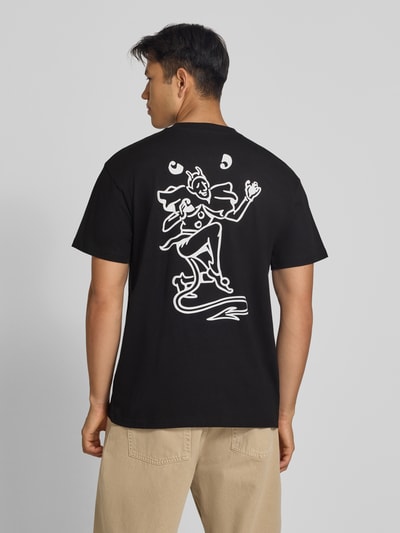 Männermodel trägt Regular Fit T-Shirt aus reiner Baumwolle Modell 'Playing Cards' von Carhartt Work In Progress mit weißem Druck, Ganzkörperansicht Rückansicht. Bio-Baumwolle, Rückenlänge Größe M 76 cm, Label-Detail.