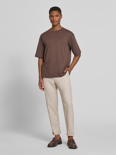 Männermodel trägt Regular Fit Stoffhose aus Baumwoll-Leinen-Mix von SELECTED HOMME in Melange-Optik, helle Webware, Ganzkörperansicht von vorne.