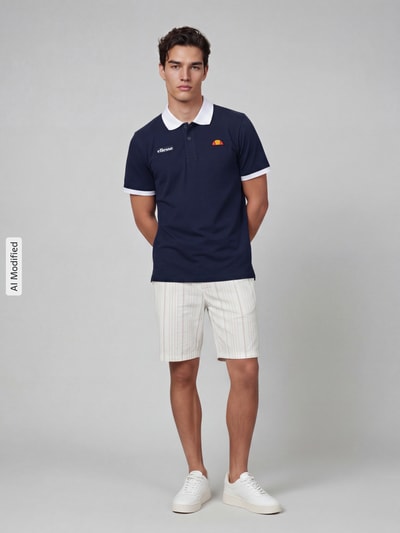 Männermodel trägt Regular Fit Poloshirt mit Label-Stitchings von ellesse in Dunkelblau mit weißem Kragen, reine Baumwolle, Ganzkörperansicht von vorne.