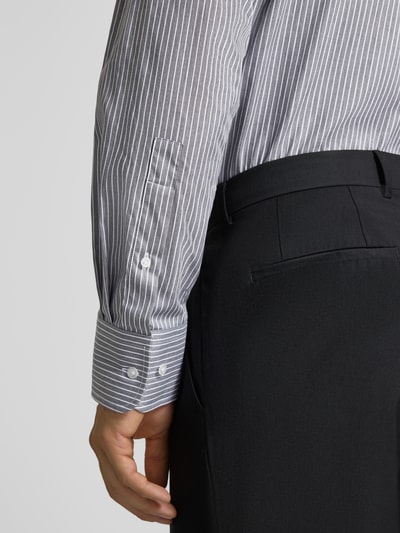 Männermodel trägt Regular Fit Business-Hemd aus Baumwolle von Christian Berg Men mit feinen weißen Streifen, Nahaufnahme Ärmel, Kontext: Herren Business-Hemd, reine Baumwolle, Regular Fit, langärmliges Design, Haifischkragen, Rückenlänge 82 cm, Schulterbreite 42 cm, Ärmellänge 65 cm.