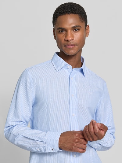 Męski model nosi Casual Fit Freizeithemd mit Kentkragen Modell 'Mike' von JOOP! Collection, jasnoniebieskie prążki, bawełniano-lniana faktura, stitching, listwa guzikowa, długość tyłu w rozmiarze M 72 cm, szerokość ramion w rozmiarze M 43 cm, długość rękawa w rozmiarze M 66 cm, widok na górną część ciała z przodu.