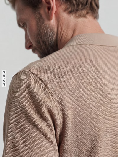 Männermodel trägt Slim Fit Poloshirt mit Strukturmuster von Christian Berg Men in Beige, reine Baumwolle, Detailaufnahme Schulterpartie.