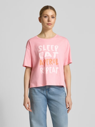 Frauenmodel trägt T-Shirt mit Motiv- und Statement-Print von Smith and Soul in Rosa, Boxy Fit, reine Baumwolle, Ganzkörperansicht von vorne.
