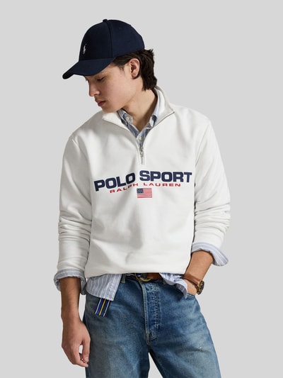 Männermodel trägt Relaxed Fit Troyer aus Baumwoll-Mix von Polo Ralph Lauren in Weiß, einfarbig mit Label-Print, gerippte Abschlüsse, Nahaufnahme Oberkörper.